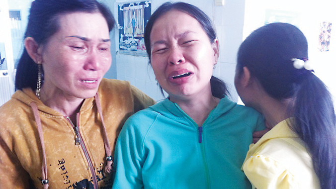 Chị Hà (giữa) đau xót nhìn con trai 2 tháng tuổi lần cuối tại Khoa Hồi sức tích cực - chống độc, Bệnh viện Nhi đồng 1 TPHCM. Ảnh: Quốc Ngọc.