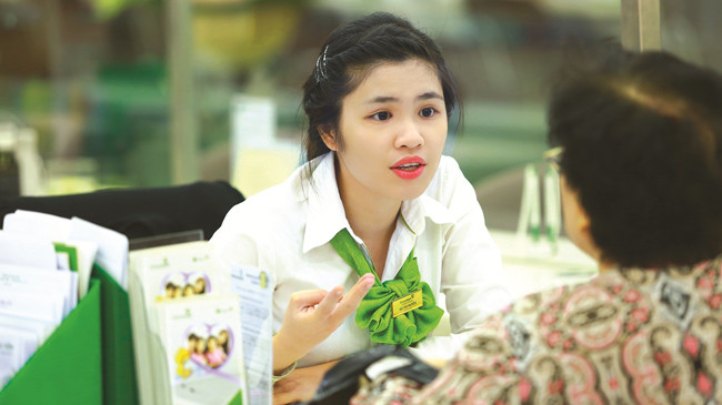 Cán bộ Vietcombank tư vấn cho khách hàng quan tâm đến sản phẩm Bảo An Gia.