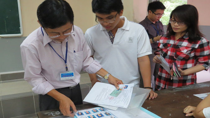 Ngoài việc thí sinh nộp ảnh gốc, năm nay phải nộp thêm ảnh file mềm để đăng tải lên hệ thống (ảnh minh họa: giám thị kiểm tra hồ sơ thí sinh dự thi ĐH,CĐ 2014).