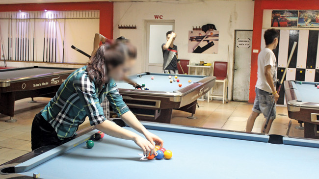 Nguyễn Thị Hoài đang làm thêm ở quán bi-a lấy tiền trả nợ cho tiệm cầm đồ. Ảnh: Quang Lộc.