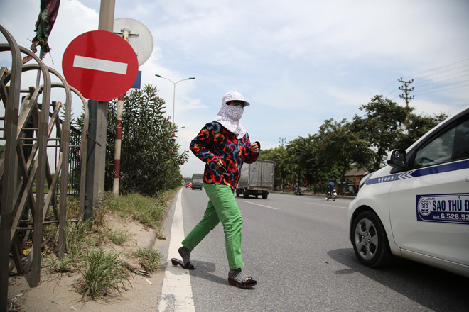 Lưu lượng xe ô tô qua đoạn đường QL5 địa phận Hải Dương rất lớn, nhưng người dân vẫn bất chấp tính mạng, xé rào băng qua đường Ảnh: Mạnh Thắng