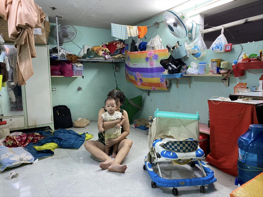 Mẹ vợ và con anh Nguyễn Văn Tuấn trong căn phòng trọ ở quận 11. Ảnh: DUY QUANG 