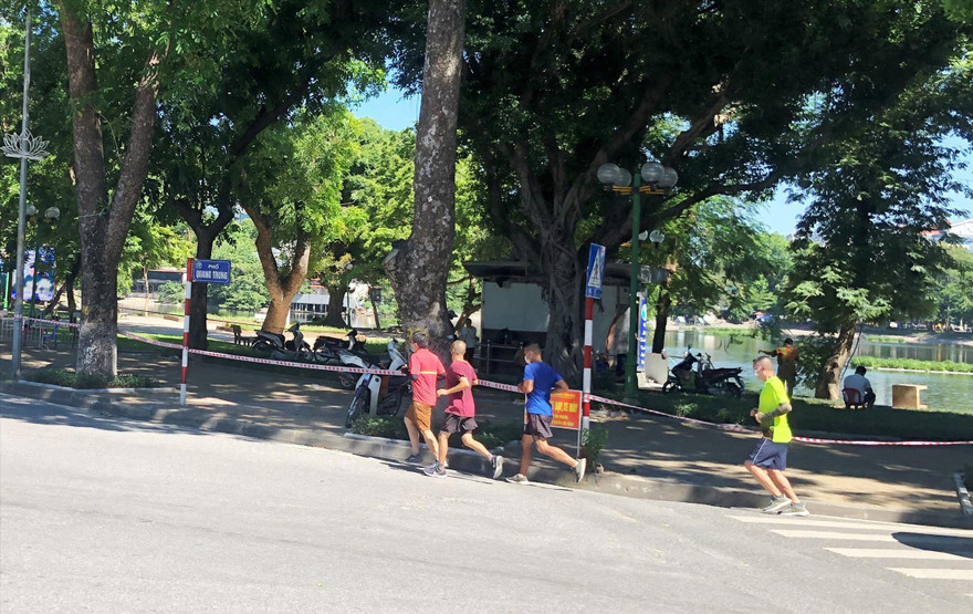 Xung quanh bờ hồ Thiền Quang chăng giây, dựng barie kín mít, người dân xuống đường chạy bộ sáng 18/6 Ảnh: Anh Trọng 