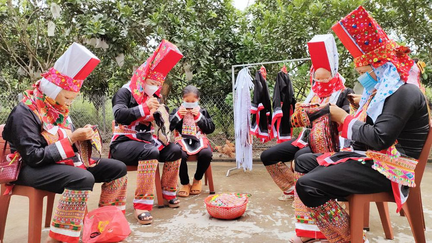 Cả gia đình quây quần tự thêu quần áo cho mình để chuẩn bị cho lễ cấp sắc