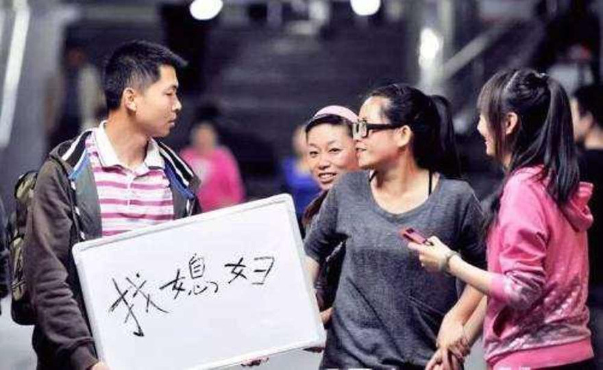 Một chàng trai mang theo tấm biển “tìm người lấy làm vợ” 