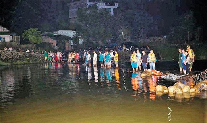 Lực lượng tìm kiếm dùng lưới rà soát 2 bên bờ suối.