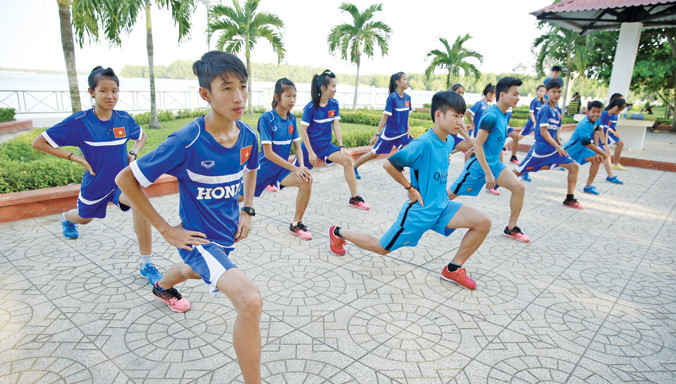 Các VĐV trẻ của Bình Phước giãn cơ bên bờ sông Hậu trước khi kết thúc buổi tập. Ảnh: Hồng Vĩnh