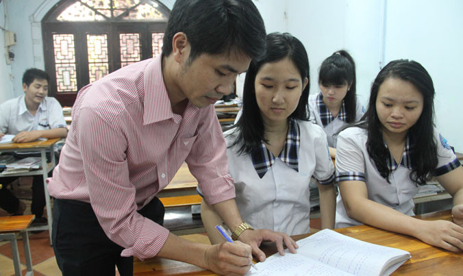 Khả Ái (ngồi giữa) đang được thầy giáo tận tình chỉ bài.