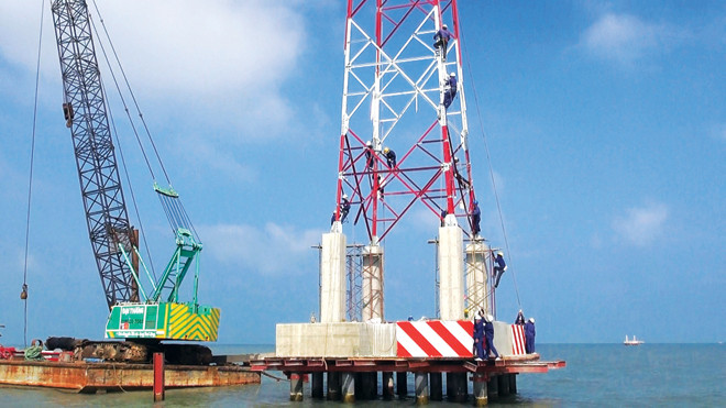 Các đơn vị đang đẩy nhanh tiến độ thi công đường dây vượt biển cấp điện lưới quốc gia cho xã đảo Lại Sơn. Ảnh: Đình Hoàng