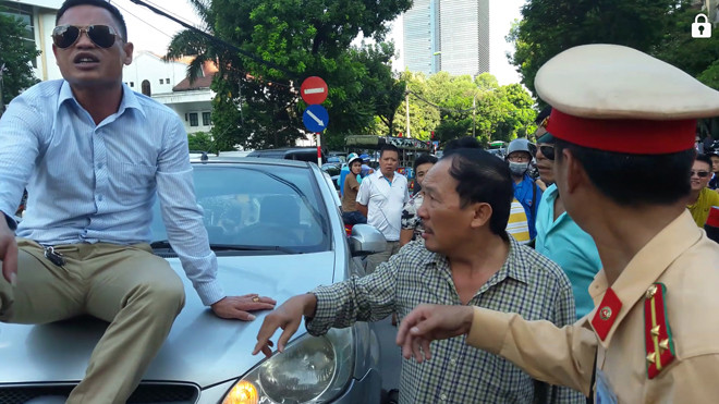 Người đàn ông vi phạm luật cố thủ trên nắp capo trên đường Láng Hạ.