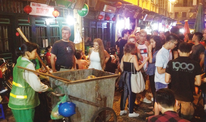 Một công nhân vệ sinh đi thu rác ở phố Tạ Hiện lúc 23h26 ngày 26/8. Ảnh: Trường Phong