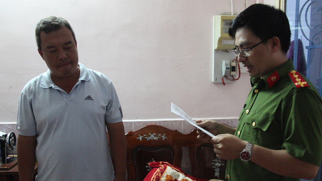 Công an đọc lệnh bắt ông Đoàn Vũ Duy, Đội trưởng Thanh tra giao thông số 11. Ảnh: Công an cung cấp.