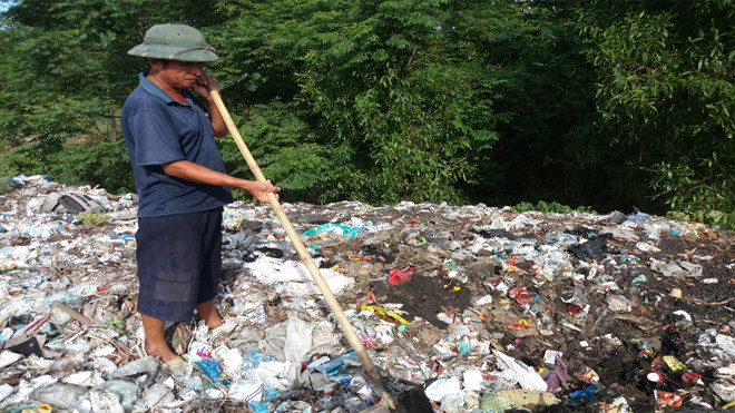 Ông Hoàng Bá Tình đang chỉ nơi chiếc xe tải đổ chất thải chở từ Formosa tại thị trấn Thiên Cầm.