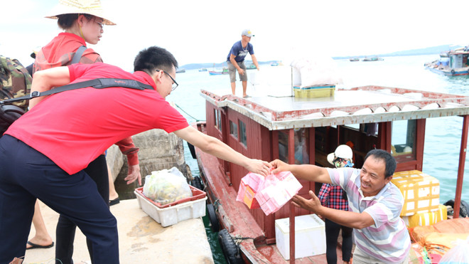 Hai bác sĩ Thanh Tùng, Hồng Lê chuyển những loại thuốc chữa bệnh cho người chủ tàu. Ảnh: P.H
