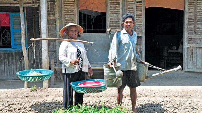 Vợ chồng ông Trần Kha trước nhà. Ảnh: Hòa Hội 