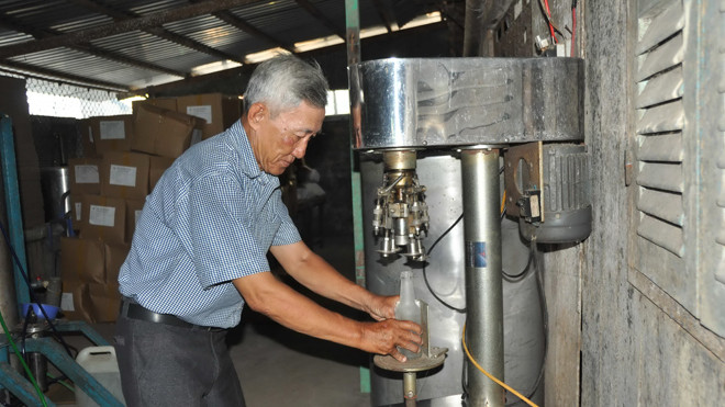 Ông Sáu Tia đang đóng nút chai bằng máy. Ảnh: Hòa Hội.