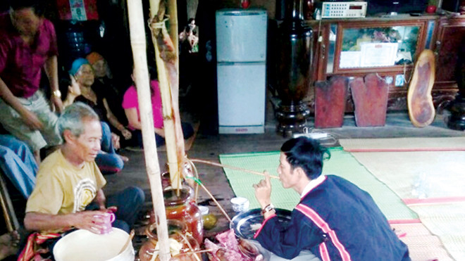 Ông Y Phắc Siu uống rượu cần để làm lễ.