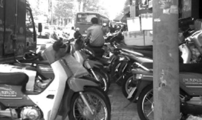 Vỉa hè đường Lê Hồng Phong quận 5, bị chiếm làm chỗ để xe, chất hàng.