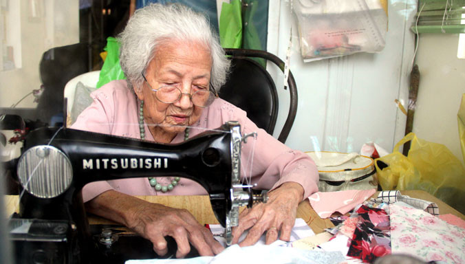 Bà Võ Thị Vân Khanh mải miết từng đường may để có những chiếc chăn ấm tặng người nghèo. Ảnh H. Văn