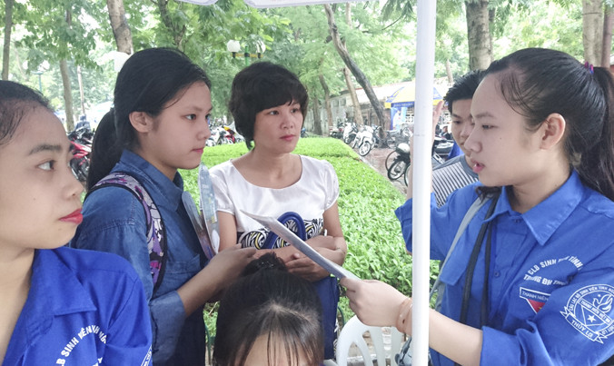 Sinh viên tình nguyện đang hướng dẫn thí sinh và phụ huynh vào làm thủ tục dự thi tại trường ĐH thủy Lợi sáng 30/6 Ảnh: Như Ý