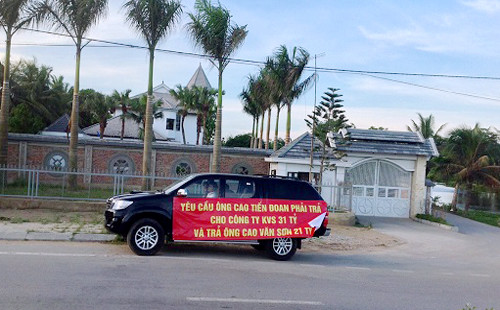 Một trong số những chiếc xe căng băng rôn đi diễu hành đòi nợ ông Cao Tiến Đoan. Ảnh: Vnexpress