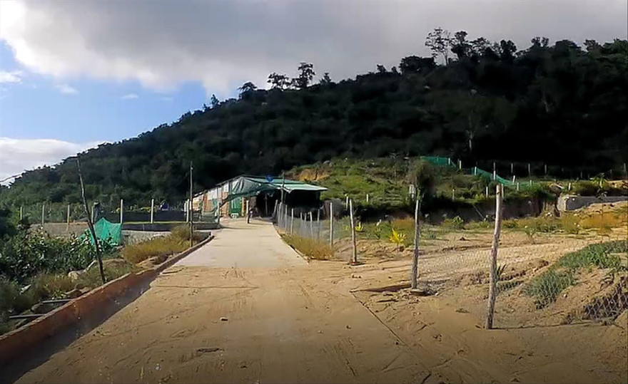 Nhiều nhà tôn kiên cố được xây dựng tại con đường bê tông mới mở tại chân núi Hòn Rồng Ảnh: Lữ Hồ 