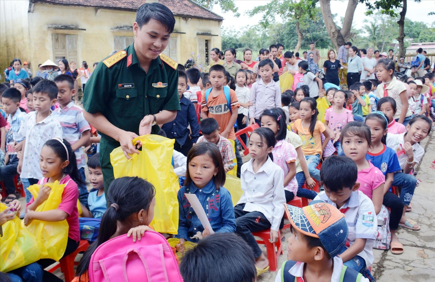 Đại úy Trần Duy Văn trao quà tặng học sinh ở xã Cẩm Lương, huyện Cẩm Thủy (Thanh Hóa) bị ảnh hưởng nặng nề do lũ lụt, năm 2018 