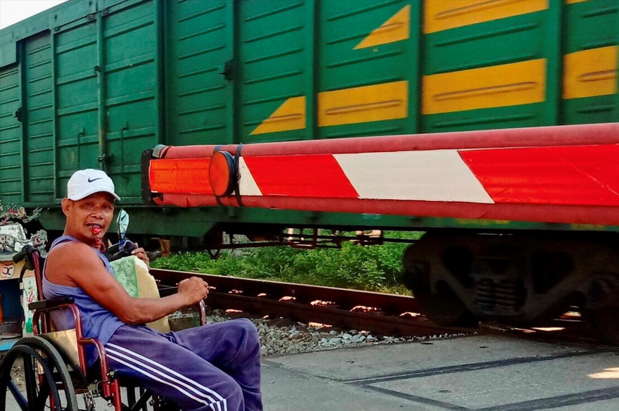 Dù tàn tật, đi lại bằng xe lăn nhưng ông Nguyễn Đức Toàn vẫn tự nguyện làm công việc gác chắn đường ngang nhiều năm nay