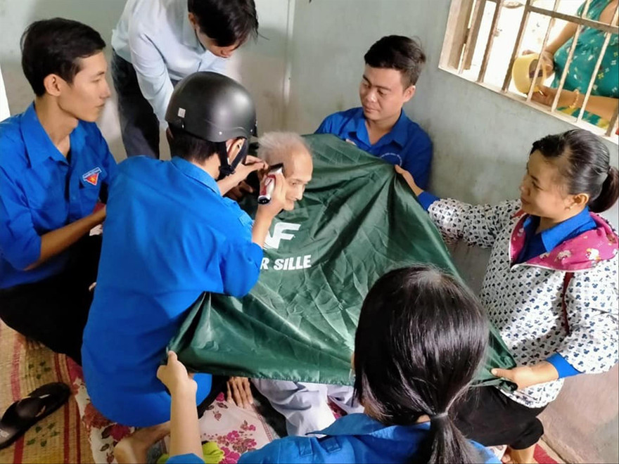 Các bạn trẻ xã Phú Đức hớt tóc cho người dân Ảnh: H.H 
