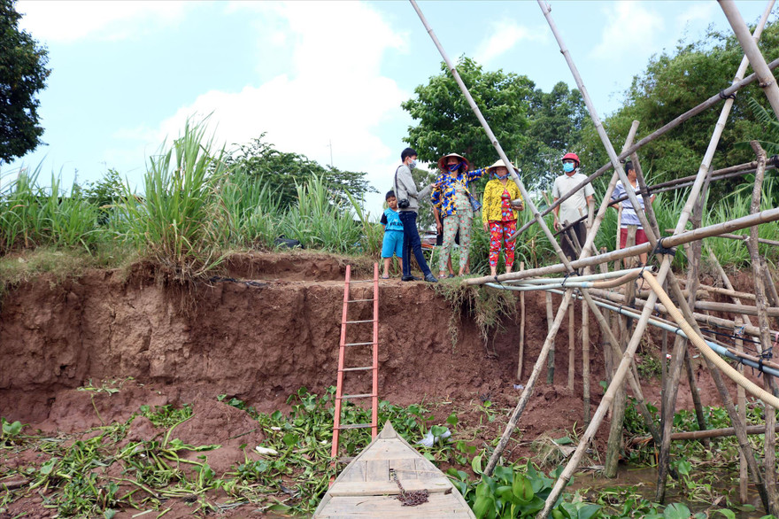 Người dân ấp Long Thượng, xã Kiến An đứng trước bờ sông vừa sạt lở do khai thác cát Ảnh: Kim Hà
