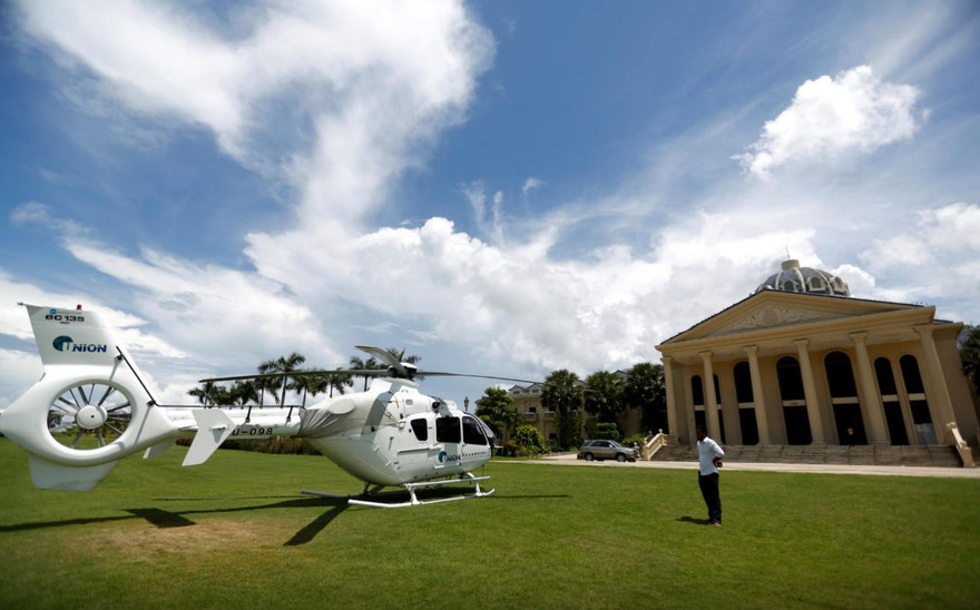 Một người đàn ông đứng cạnh chiếc trực thăng của UDG đậu trước một casino của khách sạn Dara Sakor ở Botum Sakor, tỉnh Koh Kong, Campuchia, tháng 6/2018 ảnh: Reuters 