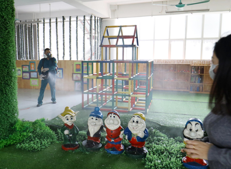 Cán bộ y tế quận Ba Đình phun thuốc CHLORAMIN B phòng chống virus tại trường tiểu học Thành Công - Hà Nội ảnh: như ý