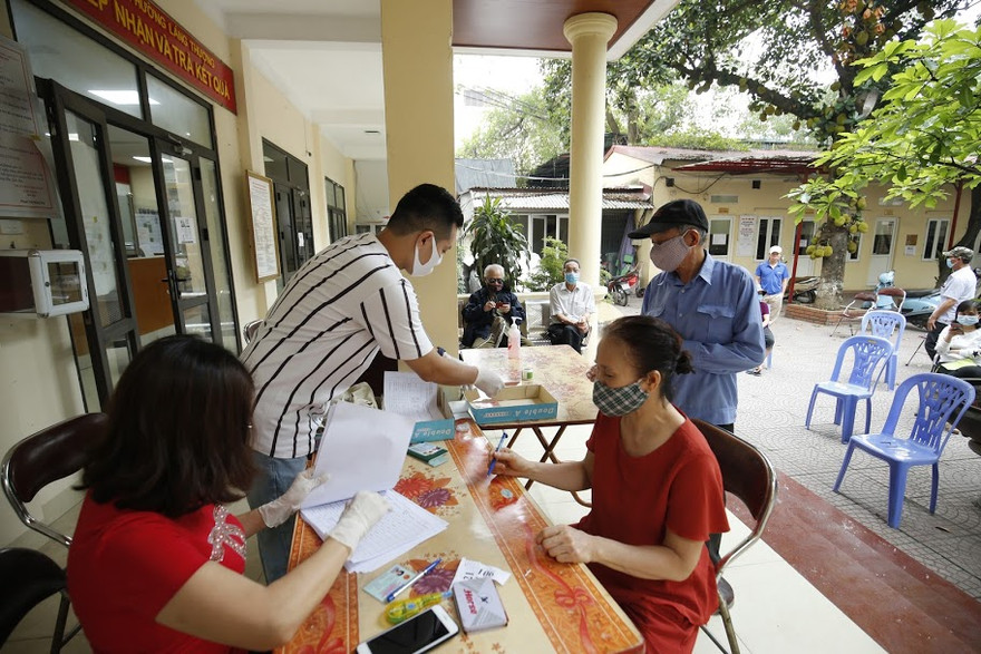 Người dân nhận tiền hỗ trợ của Nhà nước. Ảnh: Như Ý 