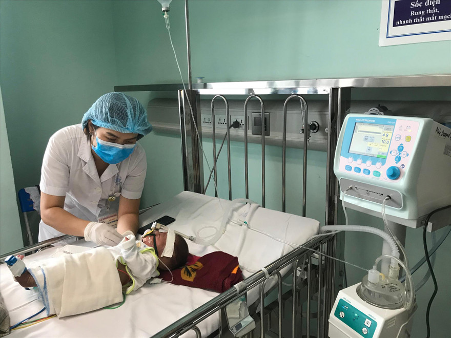 Điều dưỡng chăm sóc bé 3 tháng tuổi nhiễm virus hợp bào hô hấp phải thở oxy. Ảnh: Th. Hà