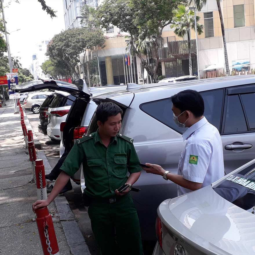 Nhân viên thu phí Nguyễn Văn Đức Vương hướng dẫn lái xe cài đặt phần mềm (app) trả phí trực tuyến khi đỗ xe trên đường Lê Lai (quận 1)