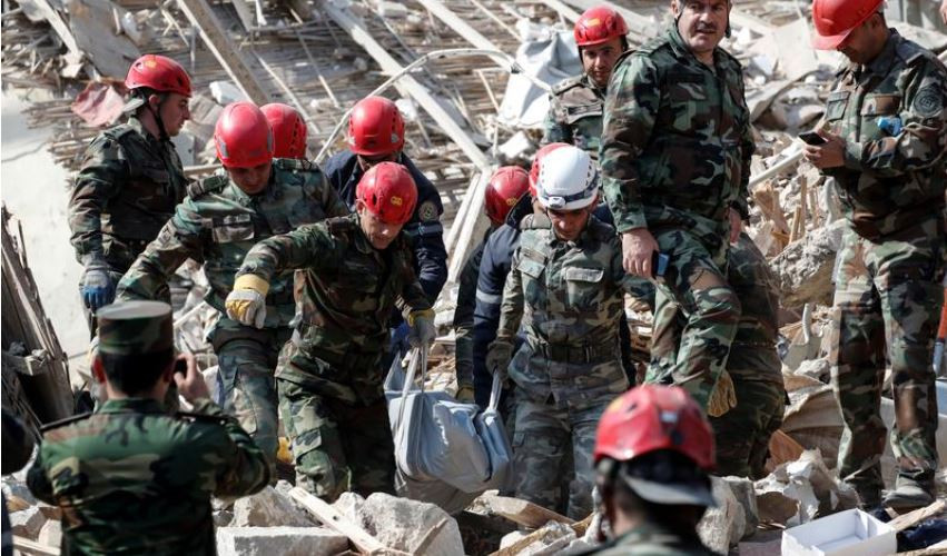 Đội cứu hộ mang thi thể một nạn nhân rời khỏi hiện trường vụ tấn ở thành phố Ganja, Azerbaijanngày 11/10. Ảnh: REUTERS 