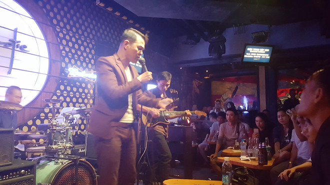 Ca sĩ Chris vừa hát vừa cầm điện thoại đọc lời “Và con tim đã vui trở lại”.