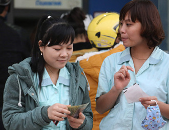 Công nhân rút tièn lương từ ATM. Ảnh: Hồng Vĩnh