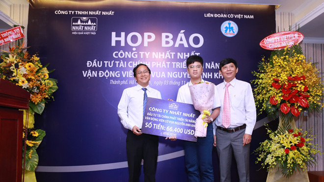 Ông Trần Thái Hoàng - Đại diện Công ty Dược phẩm Nhất Nhất trao gói đầu tư tài chính cho kỳ thủ Nguyễn Anh Khôi.