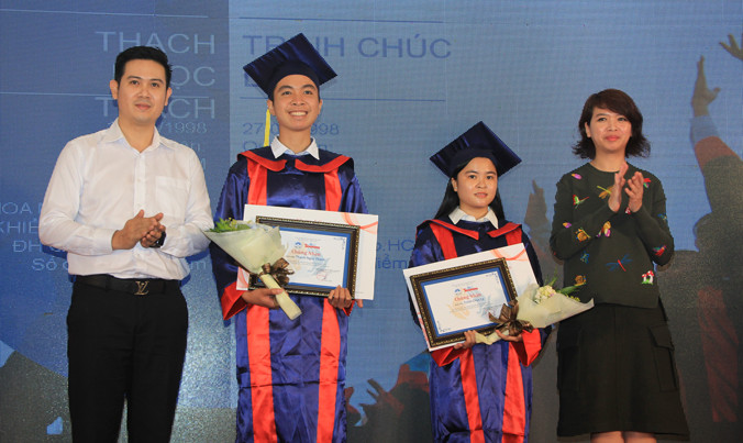 Đại diện doanh nghiệp Asanzo (bìa trái) và Novaland (bìa phải) “nâng bước” cho thủ khoa nghèo. Ảnh: Văn Minh