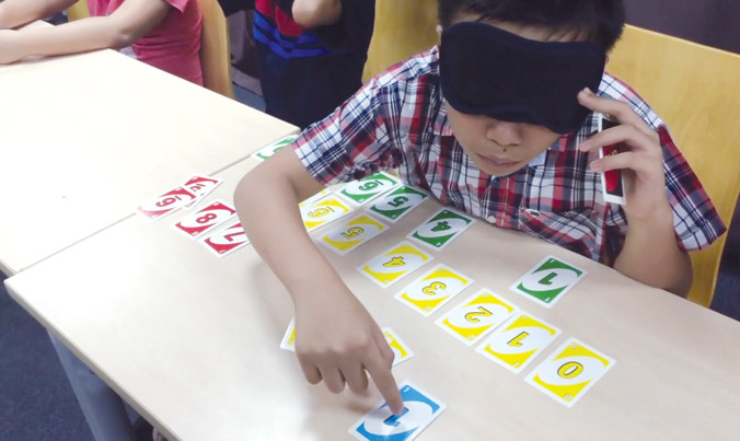 Học viên bịt mặt xếp hình hoặc đọc chữ là một trong những hoạt động của chương trình “kích hoạt não giữa”.