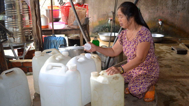 Gia đình ông Phạm Văn Thị trữ nước vào can.
