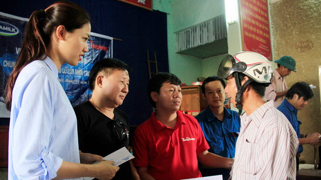 Phó Tổng Biên tập báo Tiền Phong Trần Thanh Lâm cùng ông Nguyễn Thanh Tú, đại diện lãnh đạo Cty Vinamilk và Á hậu 1 Ngô Thanh Thanh Tú trao quà cho người dân xã Quảng Lộc (Ba Đồn, Quảng Bình). Ảnh: Trường Phong