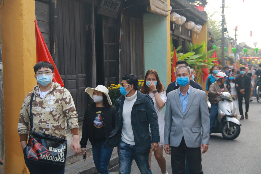 Khách du lịch đeo khẩu trang khi tham quan phố cổ Hội An 