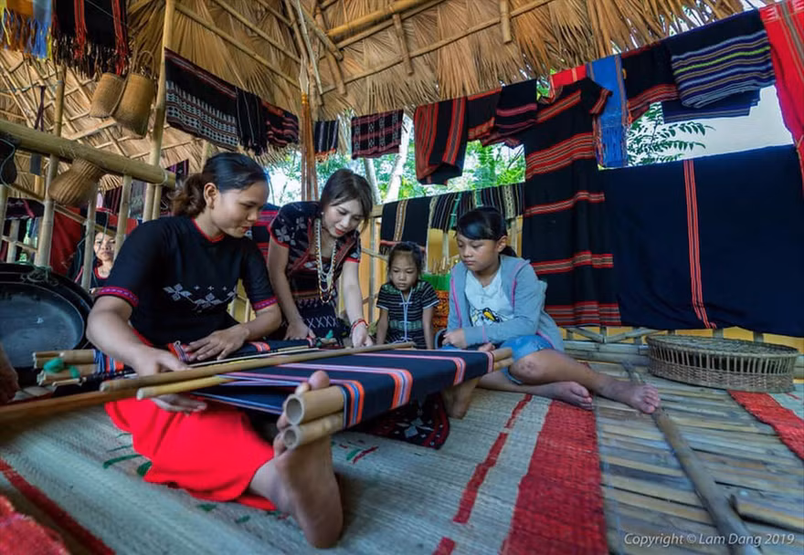 Trần Thị Một (thứ 2 từ trái sang) hướng dẫn các bạn trẻ cách dệt thổ cẩm truyền thống của người Cơ Tu. Ảnh: NVCC