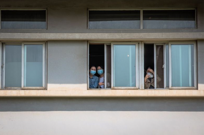 Các bệnh nhân nhìn ra từ cửa sổ bệnh viện Kim Ngân Đàm ở Vũ Hán. Ảnh: EPA-EFE