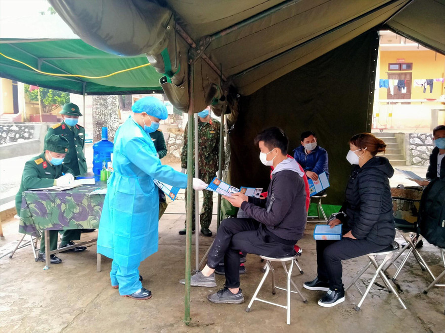 Các “chiến sỹ áo trắng” thăm khám, tiếp nhận người cách ly từ Trung Quốc trở về. Ảnh: Duy Chiến