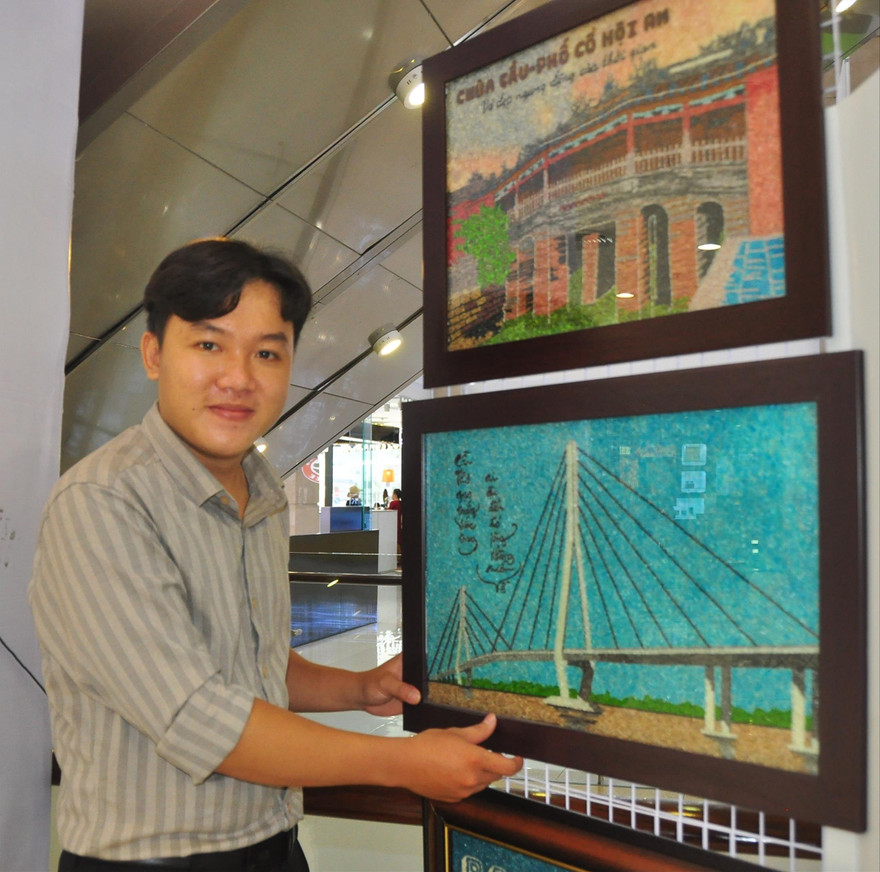 Anh Khưu Tấn Bửu, chủ cơ sở tranh gạo Tấn Bửu bên sản phẩm của mình.   ẢNH: HÒA HỘI 