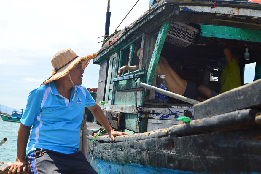Lão ngư Nguyễn Quang tranh thủ vừa thả lưới, vừa tuyên truyền cho các ngư dân trên các tàu đánh bắt gần bờ. Ảnh: Giang Thanh 