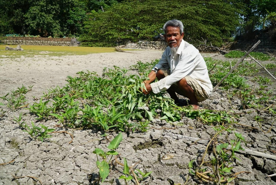 Ông Bình ngồi trên ao cá trơ đáy của mình. Ảnh: Nguyễn Ngọc